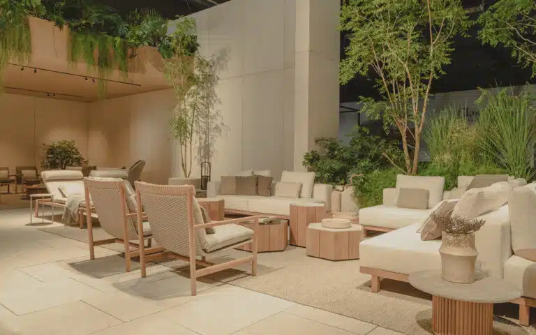 Warme loungehoek met houten stoelen, lichte banken en planten