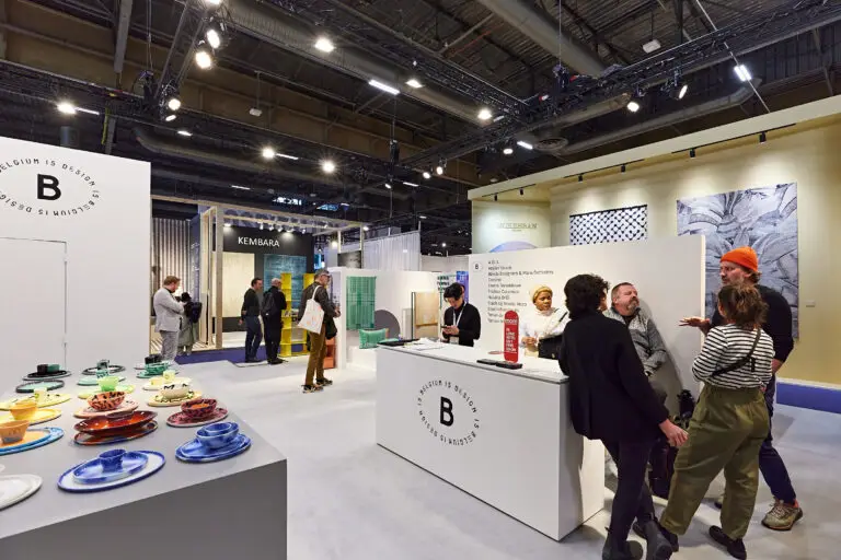 Visitors viewing products and networking at a design trade fair.